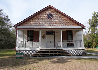 Newly rehabilitated historic building with white siding and brick upper exterior.