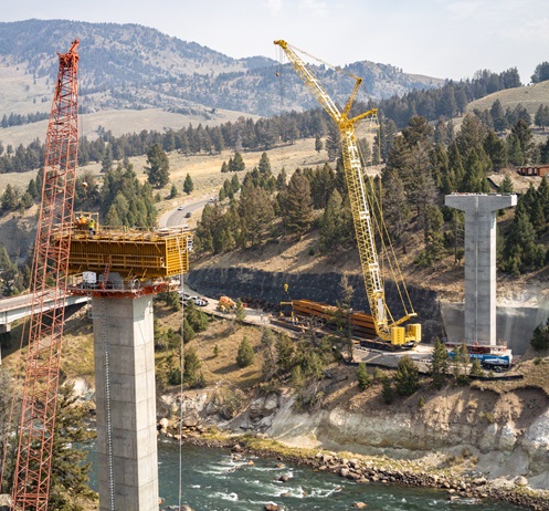 Construction cranes with concrete bridge structure in the foreground