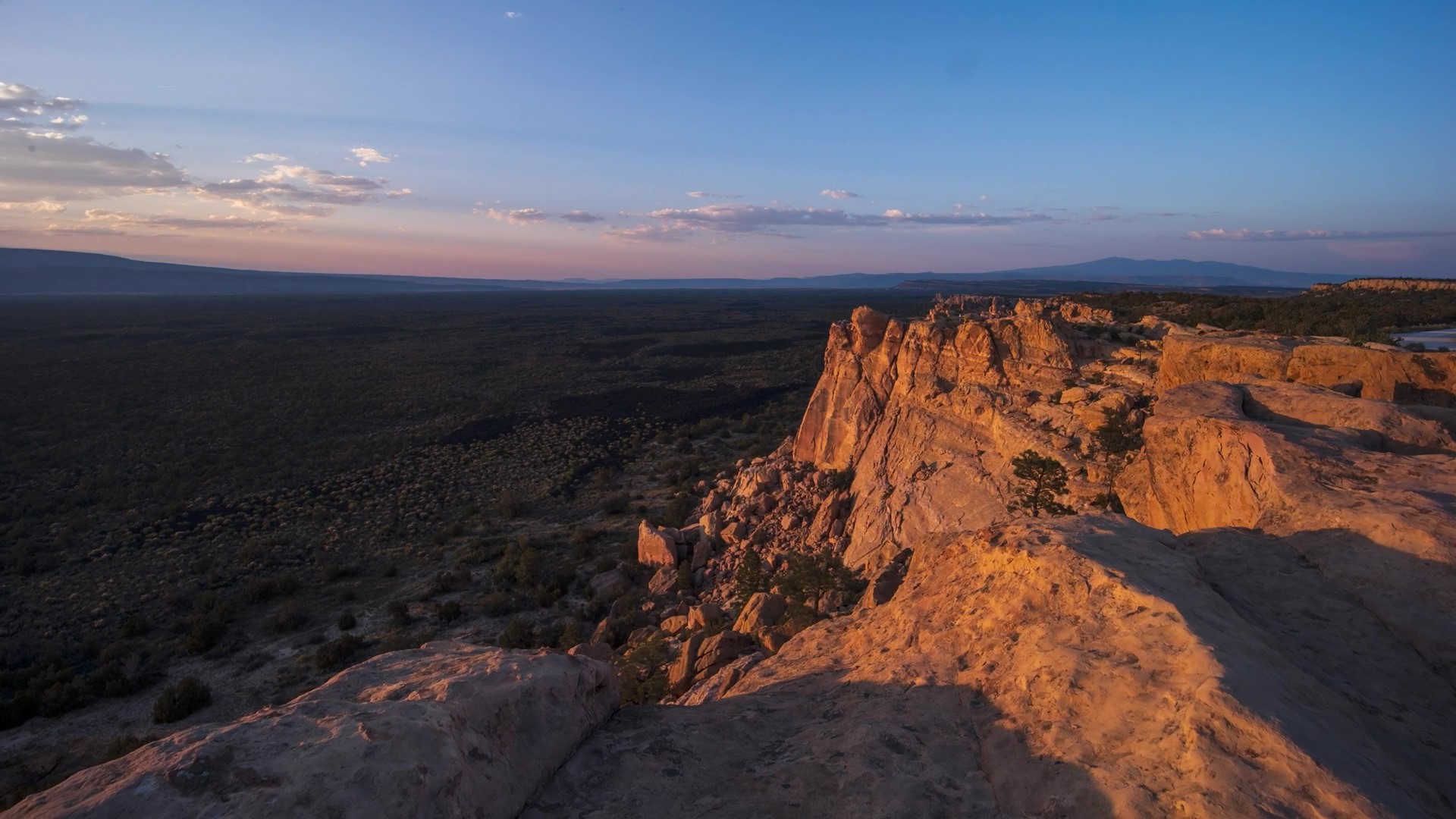Red rock cliffside with sunset in the background