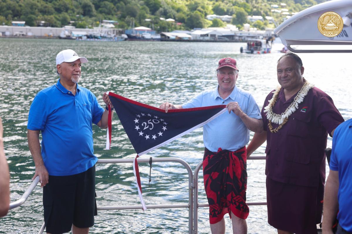 Three men holding 250 flag on a boat. 