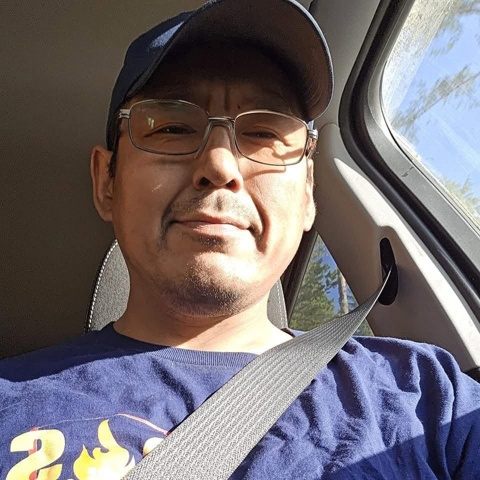 Leslie R. Washington smiles at the camera while seated in a car.