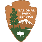 National Park Service arrowhead logo with tree, mountain, and bison