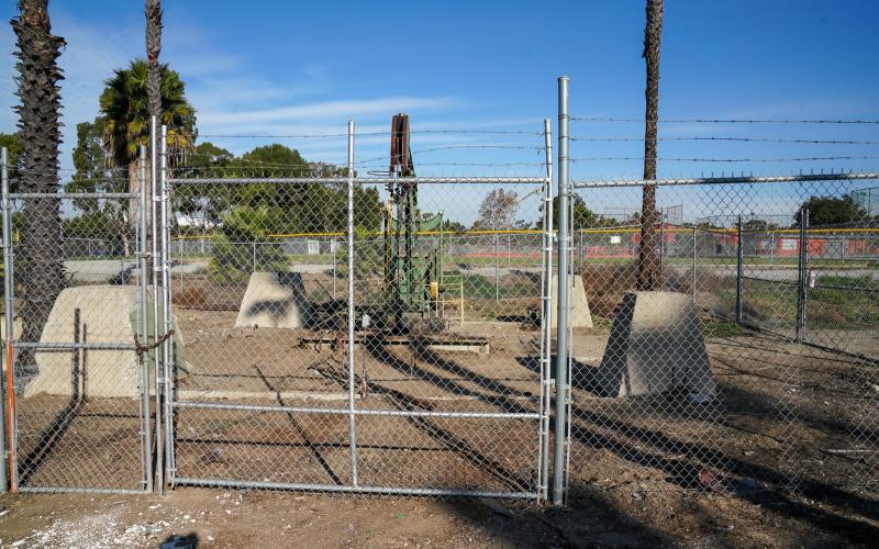 Chain-link fence surrounding oil equipment. 