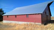 Newly rehabilitated historic barn with red siding and blue roof.