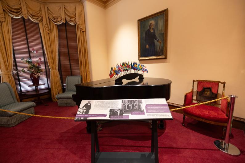 An exhibit panel in front of a grand piano