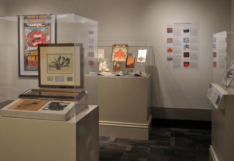 Vitrines of objects, wall graphics, and interpretive panels in the "DOI Pop!" exhibition.