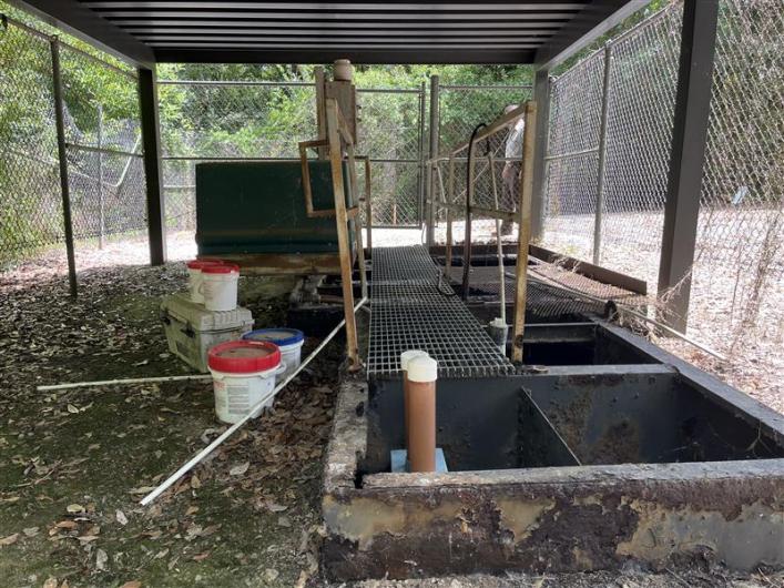Waste treatment plant surrounded by metal fence.
