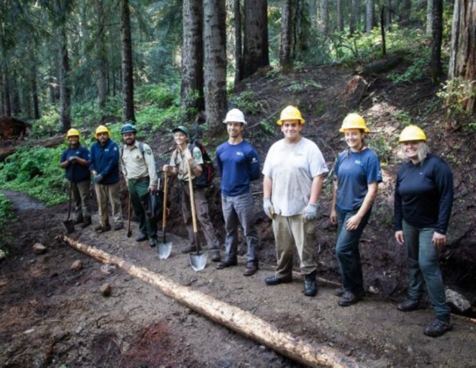 Conservation corps team members conducting trail maintenance on a dirt trail