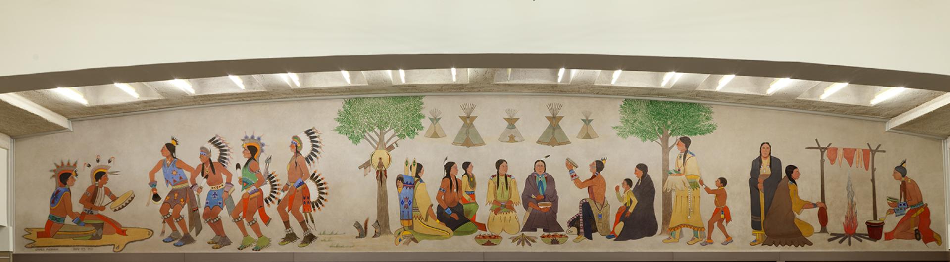 Kiowa dancers, drummers, and women preparing food frame the traditional harvest feast and Kiowa homes in the center of this painted lunette mural.