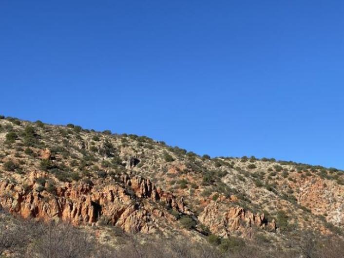 Bright blue sky over rugged wilderness covered in shrubs