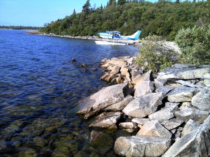 A float plane rests on the lake near shore