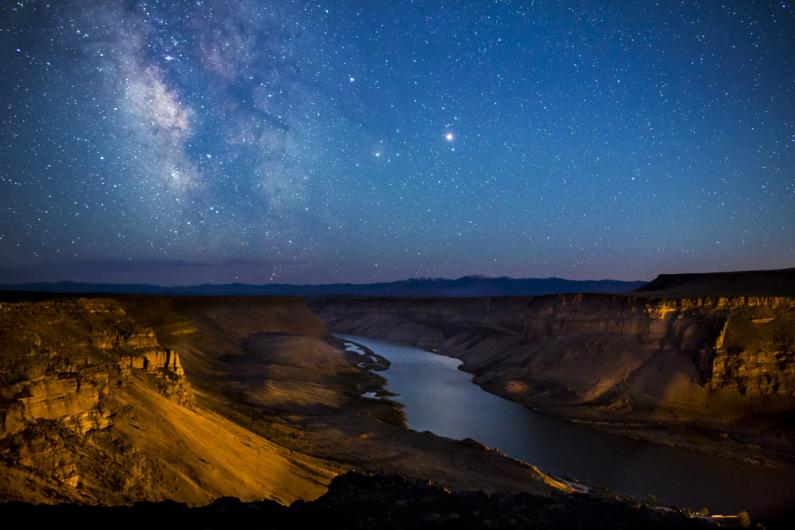 The deep canyon of the Snake River under a starry sky.