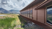 Exterior of building with red siding and windows, with mountain range in the background