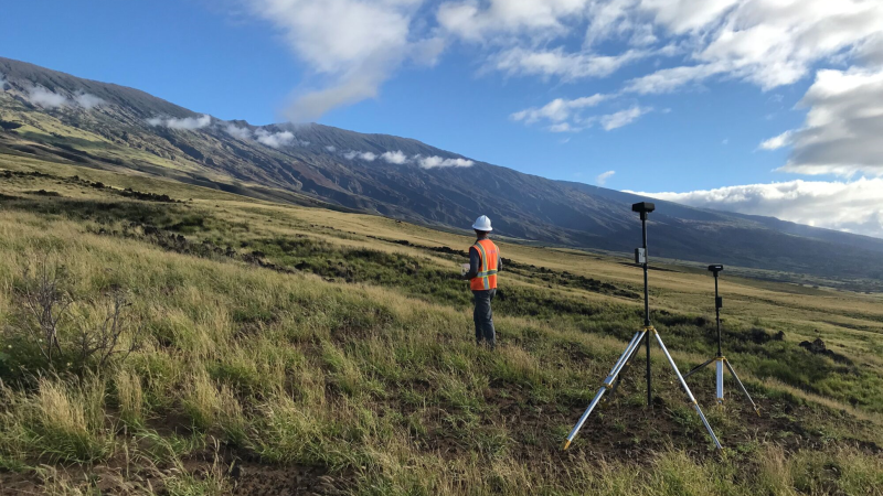 Surveyor on mountain with surveying equipment