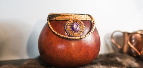 Photograph of a gourd decorated with rope and a purple gem.
