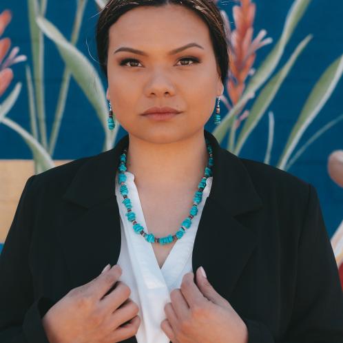 Photograph of a woman wearing a turquoise necklace.