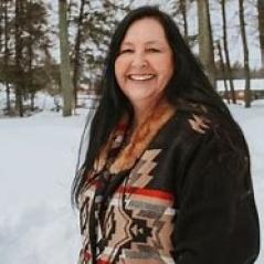 Photograph of a smiling woman with long brown hair.