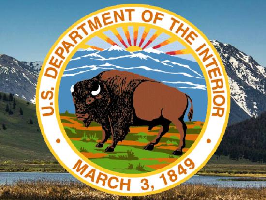 Department of the Interior bison seal set against green mountainous background