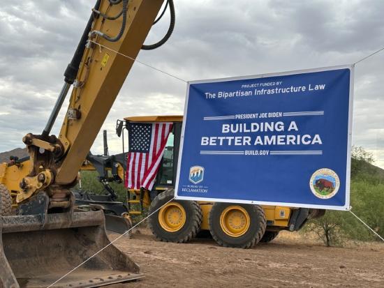 Bipartisan Infrastructure Law banner being held by large machinery.