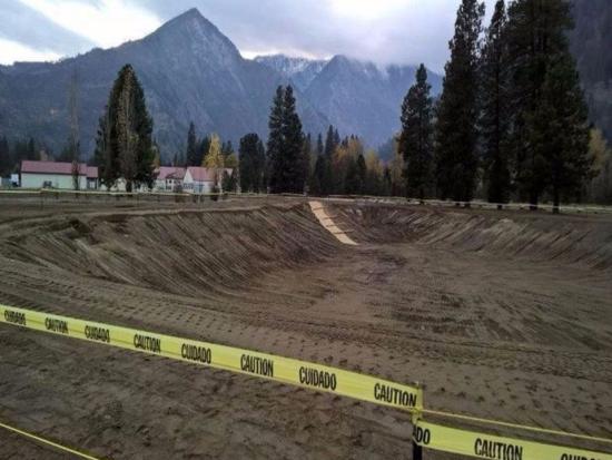 Fishpond construction zone near mountains. 