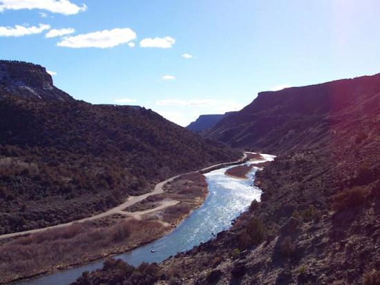 A winding river glitters in the sunlight as it flows through the Rio Grande del Norte National Monument in New Mexico.