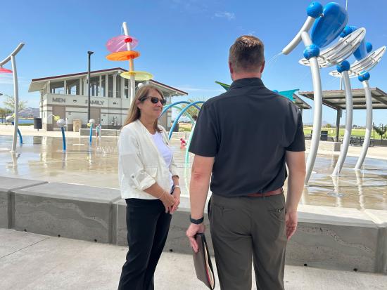 Acting Deputy Secretary Laura Daniel-Davis talking to someone in front of a splash park area. 