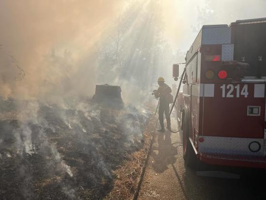 Smokey image of firefighter standing next to fire truck 