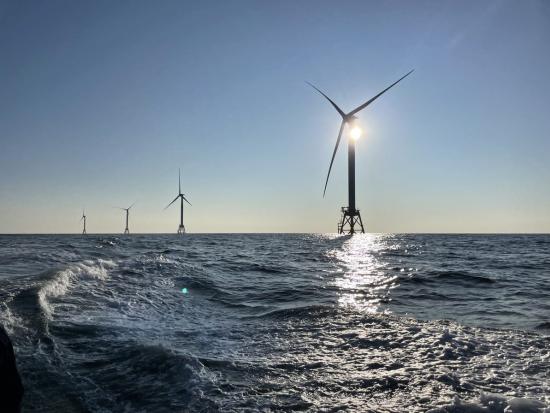 4 offshore wind turbines in the water. 