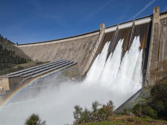 Large Dam with rainbow reflected in water. 