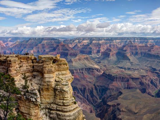 Layered rocky canyon with a blue cloudy sky. 