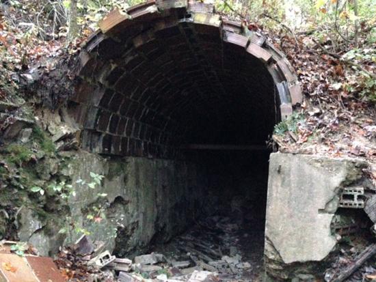 Crumbling stone archway through hillside. 