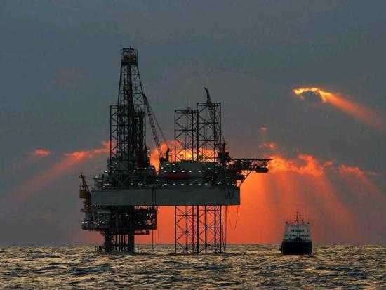 An oil rig in the Gulf of America at sunrise