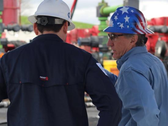 Secretary Burgum wearing red, white and blue hardhat.