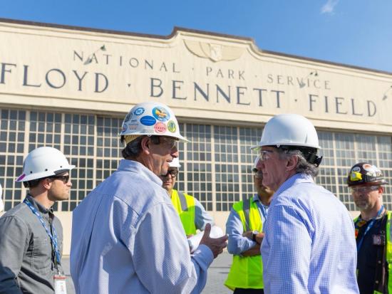 Secretary Burgum in hard hat meeting with group of people.