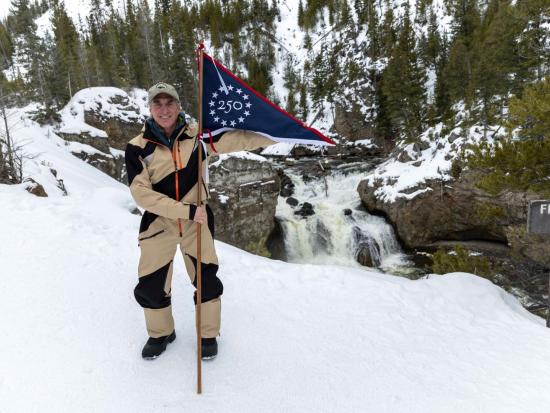 Secretary Burgum Holding GAE Flag in snowy landscape