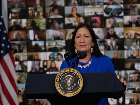 Secretary Haaland at a podium delivering remarks