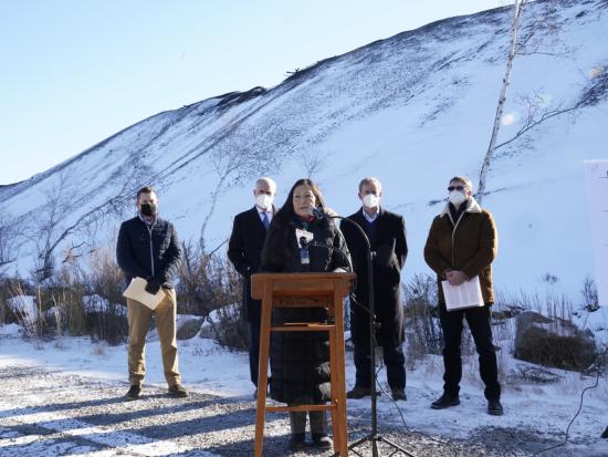 Secretary Haaland stands at a podium in front of a snowy hill.