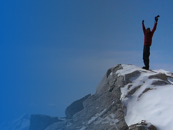 Image of a person standing on top of a snow covered mountain peak