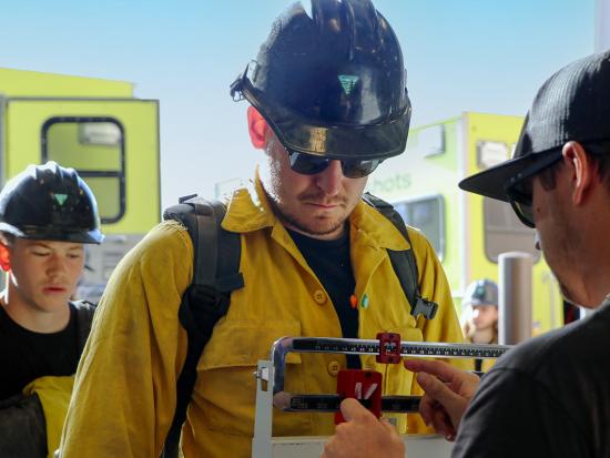 Wildland firefighter stands on scale and is weighed. Photo by Jennifer Myslivy, BLM.