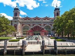 View from the water of a large red and white building with red metal gazebo at the front. 