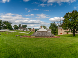 Lush green grass field with buildings in the background