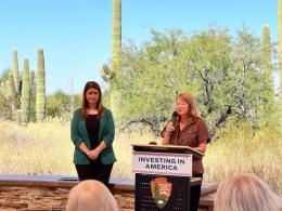 Laura Daniel Davis stands at a podium as she announces the funding. 