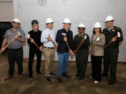 Group photo of people wearing hardhats and holding mallets. Some are in NPS uniform, and others wear suits.