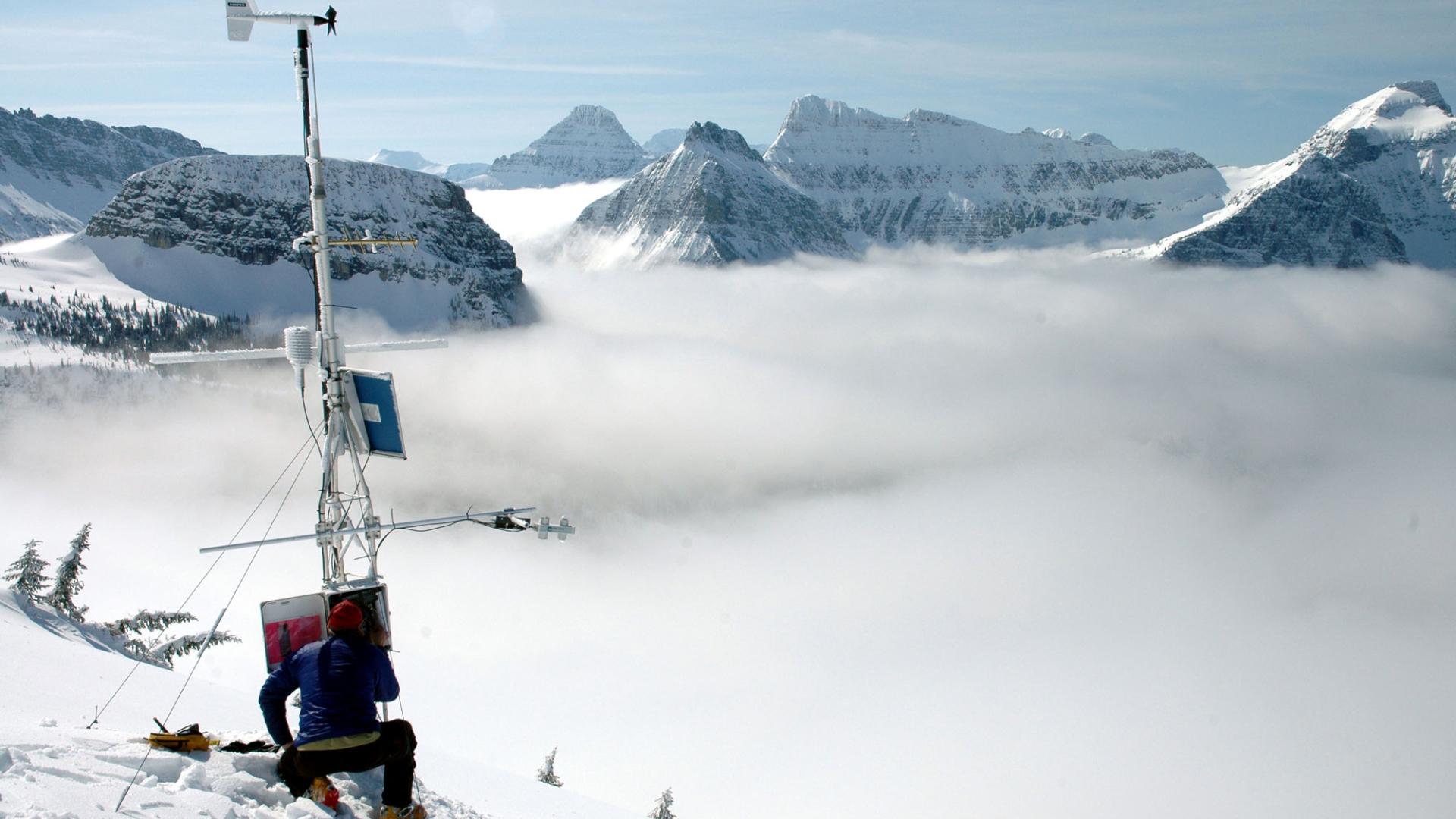 Scientist conducting research on snowy mountain landscape.